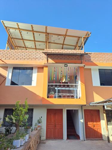 un edificio con balcón con banderas. en Casa Kutimuy en Ayacucho