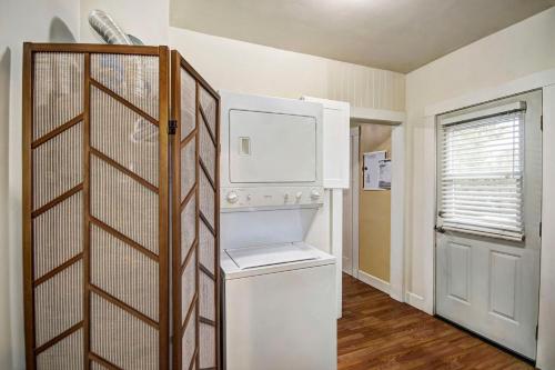 a small kitchen with a white refrigerator and a door at Charming 2Bed French Colonial Apartment in Desirable Midtown Sacramento in Sacramento