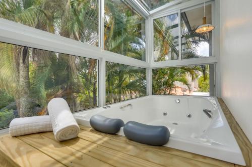 a bath tub in a room with a large window at Solar Beach Hotel in Florianópolis