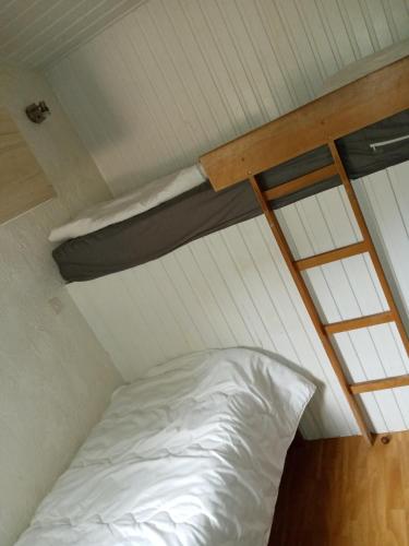 a white bed in a small room with windows at Le repaire des belettes Vallée de Rabais in Virton