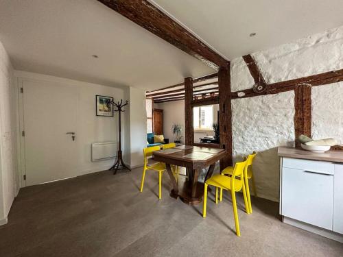 une salle à manger avec une table et des chaises jaunes dans l'établissement nouvel appartement, Le Colombage Heureux, à Sélestat