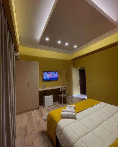 a bedroom with a bed and a desk and a tv at Hotel Xhelili in Cërrik