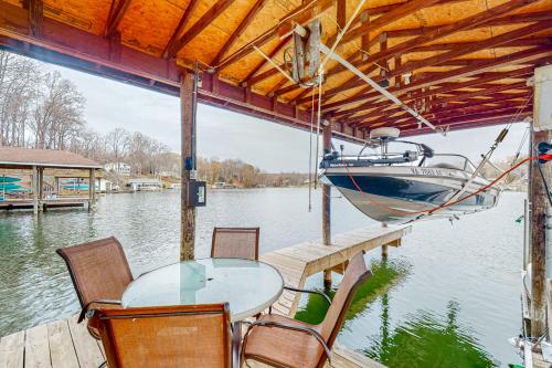 a table and chairs on a dock with a boat at A Kerr Home in Moneta