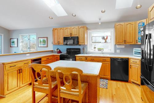 a kitchen with wooden cabinets and a table and chairs at The Lake House on Sunset Point in Moneta