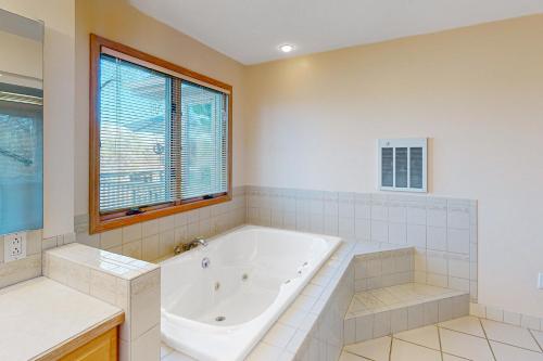 a large bathroom with a tub and a window at The Lake House on Sunset Point in Moneta