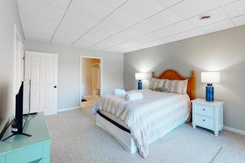 a bedroom with a bed and a flat screen tv at The Lake House on Sunset Point in Moneta