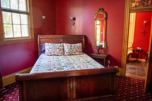 a bedroom with a bed in a red room at The Lookout Inn in New Orleans