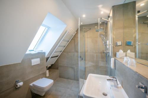 a bathroom with a toilet sink and a staircase at Hotel Königslinie in Sassnitz