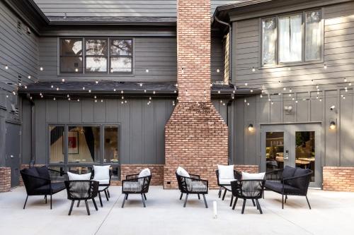 a patio with black chairs and tables in front of a building at Kasa Edison House South End Dilworth Charlotte in Charlotte