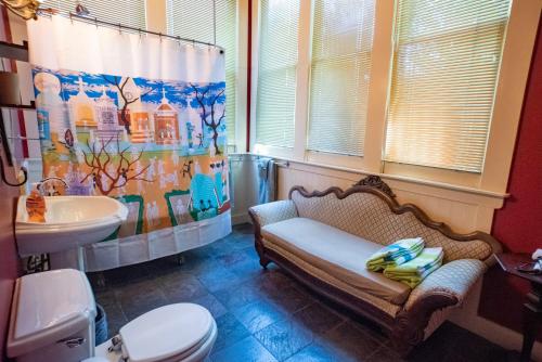 a bathroom with a bench and a sink and a shower curtain at The Lookout Inn in New Orleans
