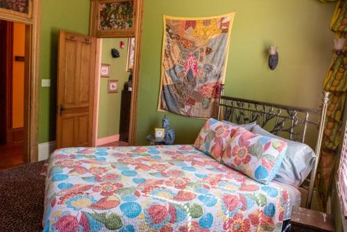 a bedroom with a bed with a colorful comforter at The Lookout Inn in New Orleans