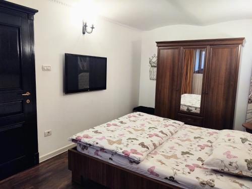 a bedroom with a bed and a dresser in it at CezAri ApartHotel in Braşov