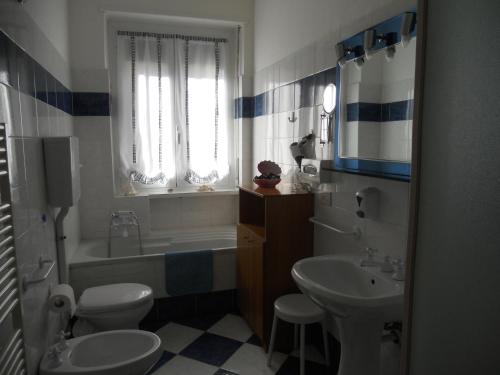 La salle de bains est pourvue d'un lavabo, de toilettes et d'une baignoire. dans l'établissement B&B Home Sweet Home, à Diano Marina