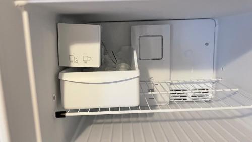 a refrigerator with its door open with a white refrigerator at The Blue Door at Sylva Home Base Apartments in Sylva
