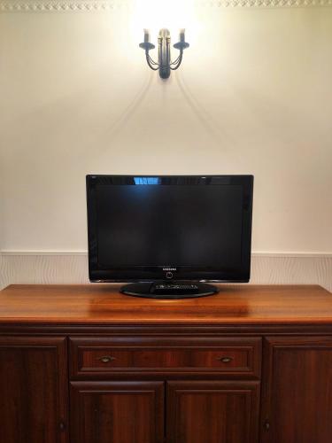 a flat screen tv sitting on top of a wooden cabinet at CezAri ApartHotel in Braşov
