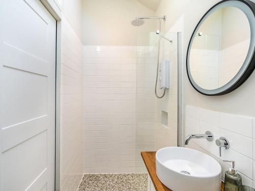 a white bathroom with a sink and a mirror at Little Glencrest in Copley