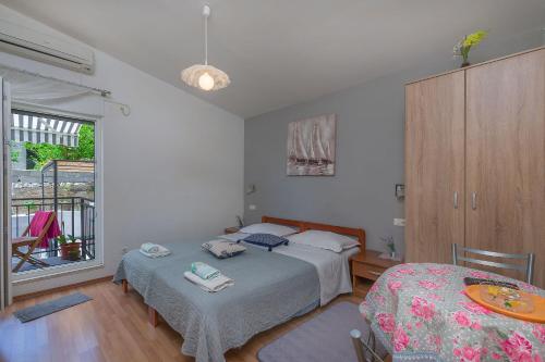 1 dormitorio con cama, mesa y ventana en Apartment Goge, en Omiš
