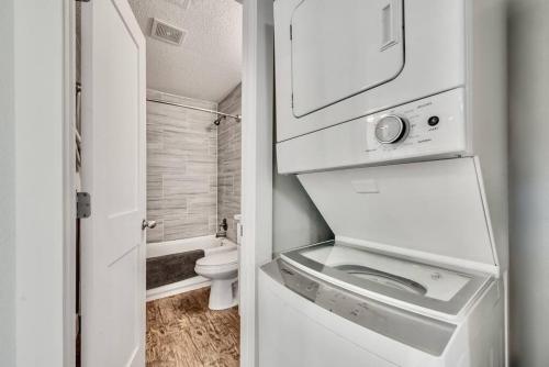 a white bathroom with a toilet and a sink at Lovely Dallas Flat Near Downtown in Dallas