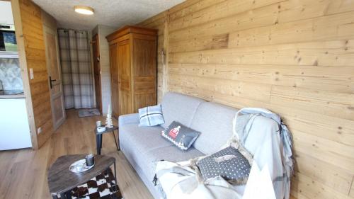 uma sala de estar com um sofá e uma parede de madeira em L'OURALOU - Vue panoramique em Les Gets