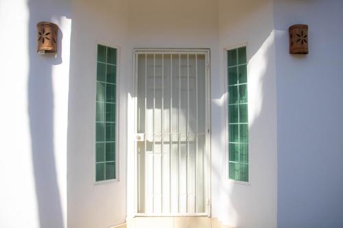 a white door in a white building with two windows at Casa en Altata Las Aguilas, Nav. Sinaloa in Altata