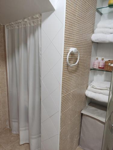a shower with a white shower curtain in a bathroom at Alojamiento turístico Carvi in Arévalo