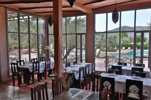 a restaurant with tables and chairs with a view of a pool at Ksar Shama in Ouirgane