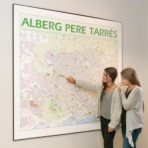 two women standing in front of a map at Barcelona Pere Tarrés Youth Hostel in Barcelona