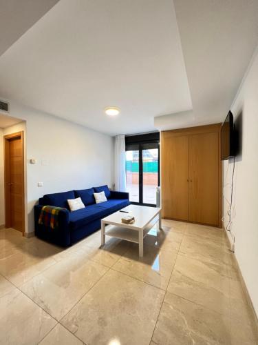 un soggiorno con divano blu e tavolo di Fabuloso apartamento completo centro ciudad a Móstoles