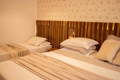 um quarto de hotel com duas camas e uma parede de madeira em Swiss Garten Jeri em Jericoacoara