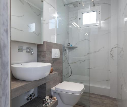 a bathroom with a sink and a toilet and a shower at Studios Halkia in Toroni