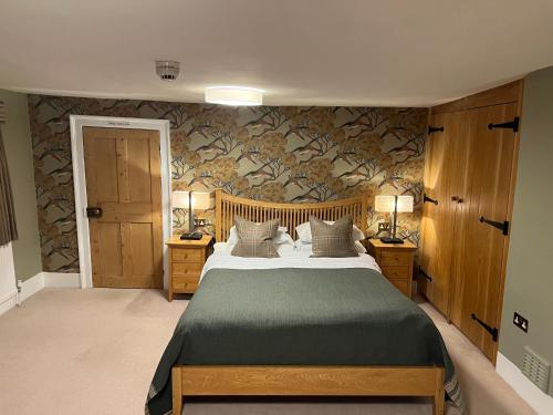 a bedroom with a bed and two night stands with lamps at Mulberry House in Ongar