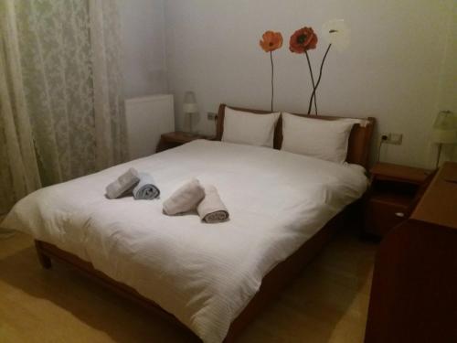 a bedroom with a white bed with towels on it at MUSEUM apartment in Volos