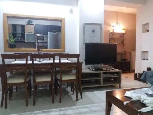 a living room with a dining room table and a television at MUSEUM apartment in Volos