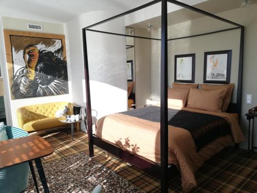 sypialnia z łóżkiem z baldachimem i lustrem w obiekcie Monts Dôme w mieście Clermont-Ferrand