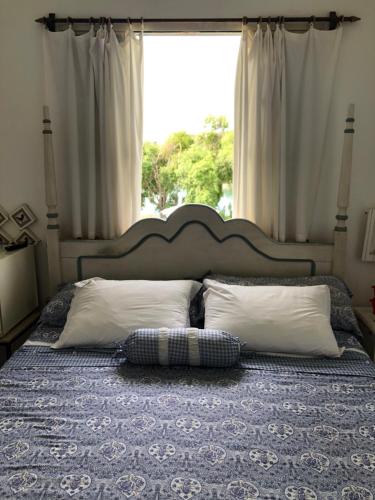 a bedroom with a bed with a large window at Villa Interlagos de Minas in Guapé