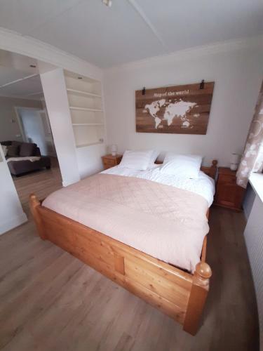 1 dormitorio con cama de madera y mapa en la pared en B&B de Maalderi-je en Winterswijk