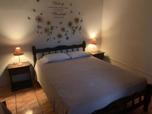 1 dormitorio con 1 cama grande con flores en la pared en Linda Vista Cabins, en Boquete