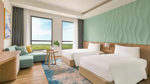 a hotel room with two beds and a couch at Holiday Inn Resort Ho Tram Beach by IHG in Ho Tram