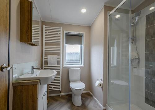 uma casa de banho com um WC, um lavatório e um chuveiro em Green Meadows Country Park em Harker