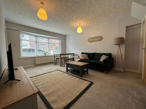 a living room with a couch and a table at Cosy, 2 Bedroom Cottage in Guisborough Town Centre in Guisborough