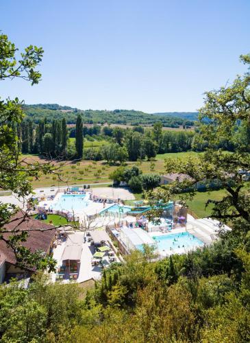 une vue aérienne d'un grand parc aquatique dans l'établissement Camping Moulin de Paulhiac, à Daglan