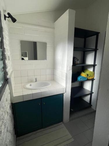 La salle de bains est pourvue d'un lavabo et d'un miroir. dans l'établissement Hébergement tout équipé et surveillance H24, à Koungou