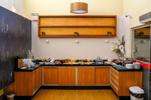 a kitchen with a counter with food on it at Goldmen Business Hotel in Cianorte