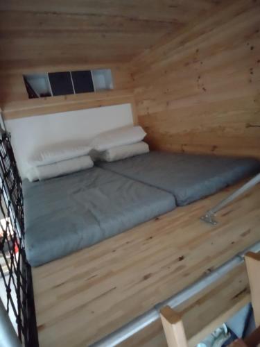 - un lit dans une petite maison dans une cabane en bois dans l'établissement Roomy studio near town and ski lift, free WiFi and parking, à Saint-Gervais-les-Bains