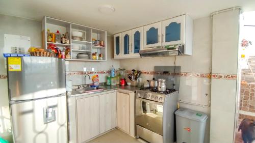 uma cozinha com armários brancos e um frigorífico em El Cerezo Casa de campo em Tópaga