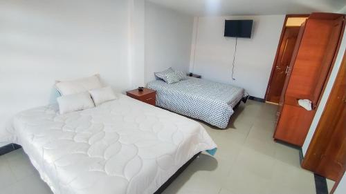 a bedroom with a large white bed in a room at El Cerezo Casa de campo in Tópaga