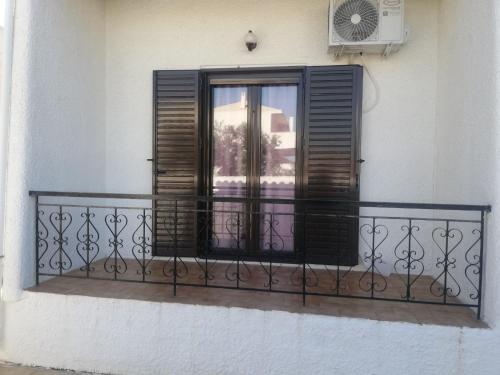 a balcony with a window and a window shutter at Sunhouse Vrachati in Vrahati