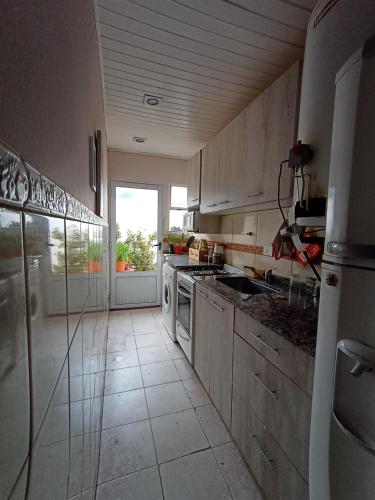 cocina con electrodomésticos blancos y ventana grande en Casa para 4 personas en San Carlos de Bariloche