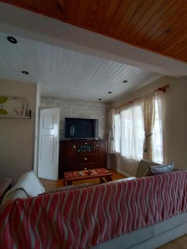 sala de estar con sofá y TV de pantalla plana en Casa para 4 personas en San Carlos de Bariloche
