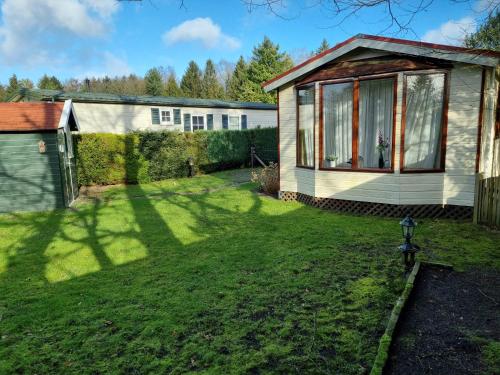 a backyard with a house and a yard with a house at Camping Vossenberg - op de Veluwe! in Epe